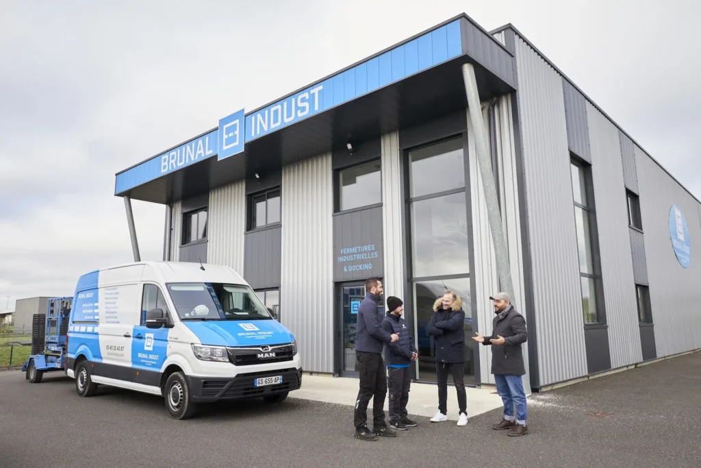 Batiment Brunal Indust avec 4 personnes devant